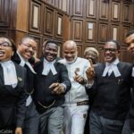 Despite Bail Denial, Nnamdi Kanu Strikes Funny Pose With Lawyers In Court [Photos]