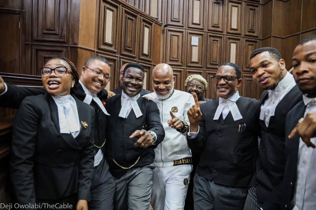 Despite Bail Denial, Nnamdi Kanu Strikes Funny Pose With Lawyers In Court [Photos]