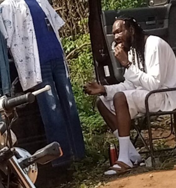 Outrage As Man Shares Photo Of Actor Sylvester Madu Selling Clothes And Eating On Bushy Road